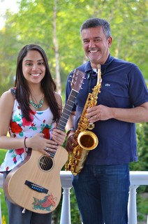 Girl holding a guitar and a man holding a saxophone